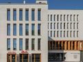 Von Weitem ziehen die Stadtloggia und die Fensterrahmen aus Holz sowie das Logo neben dem Eingang des Neuen Rathauses in Bernau bei Berlin die Blicke an. 